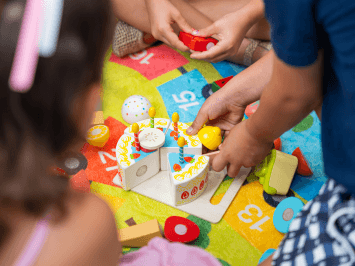 Children playing with a toy birthday cake during a play activity